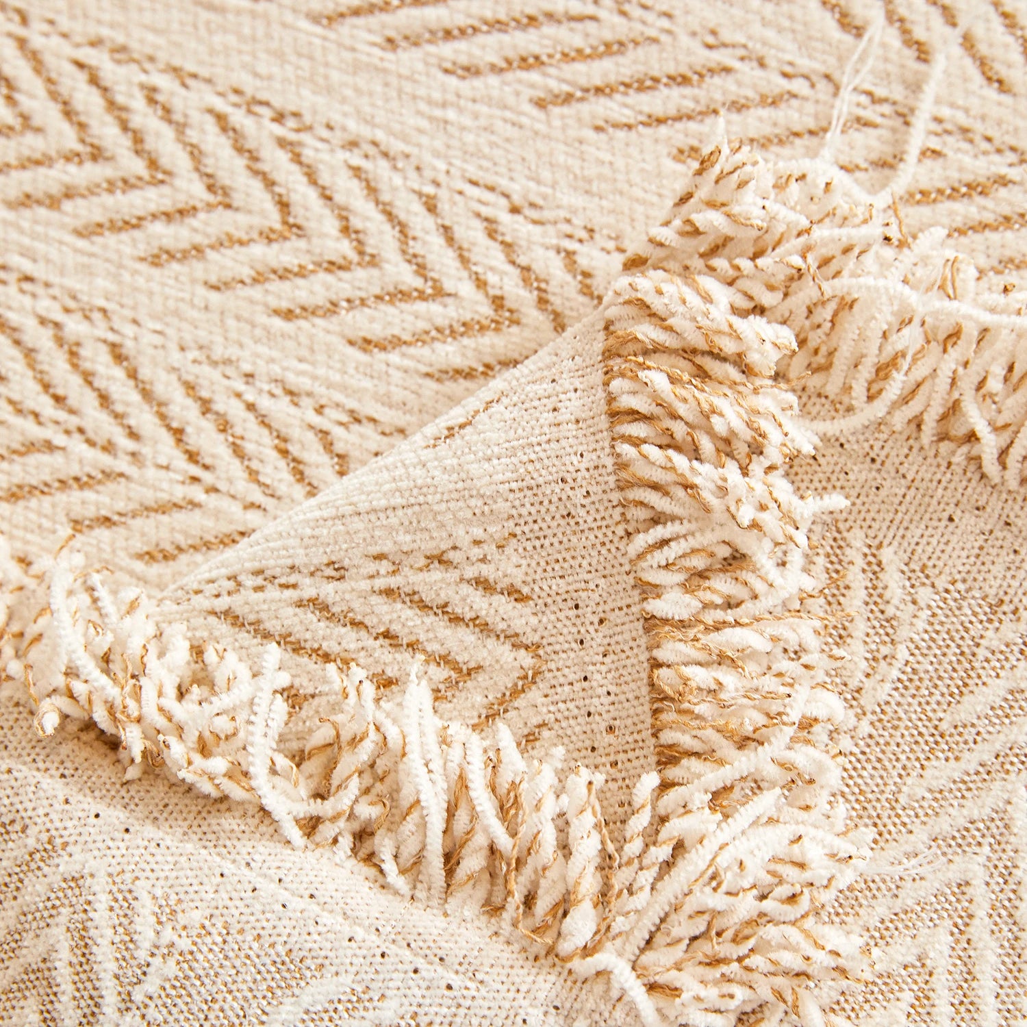 Close-up of a textured couch cover fabric with cream or beige chevron pattern. 